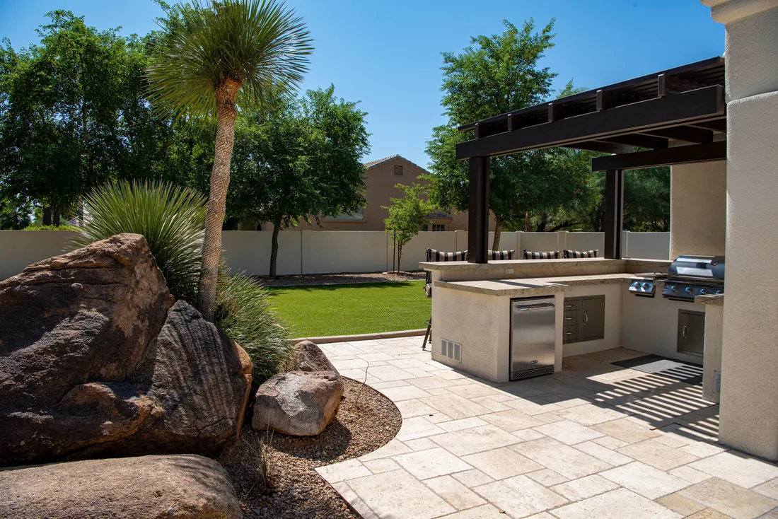 The finished terrace with a stone kitchen, boulder planting and paving