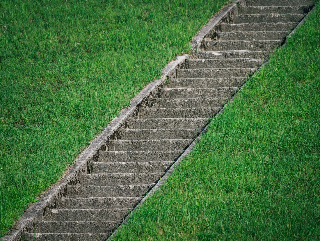 A stone staircase cut through a steep lawn